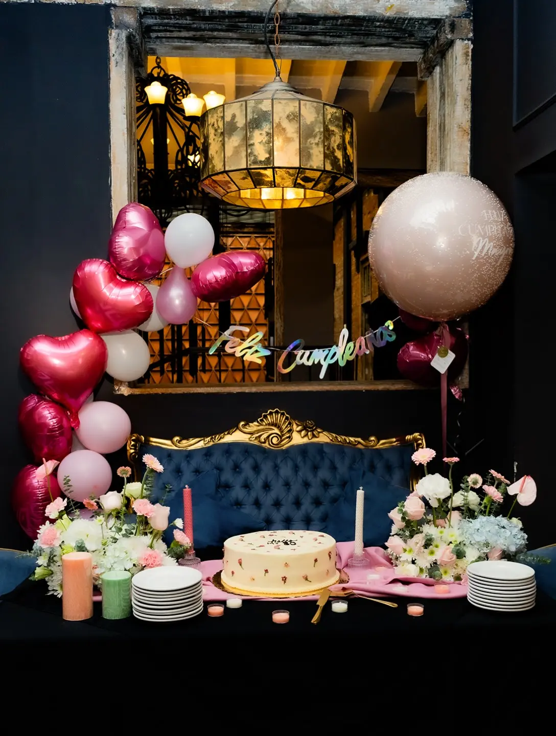 Mesa decorada con globos y pastel para un cumpleaños