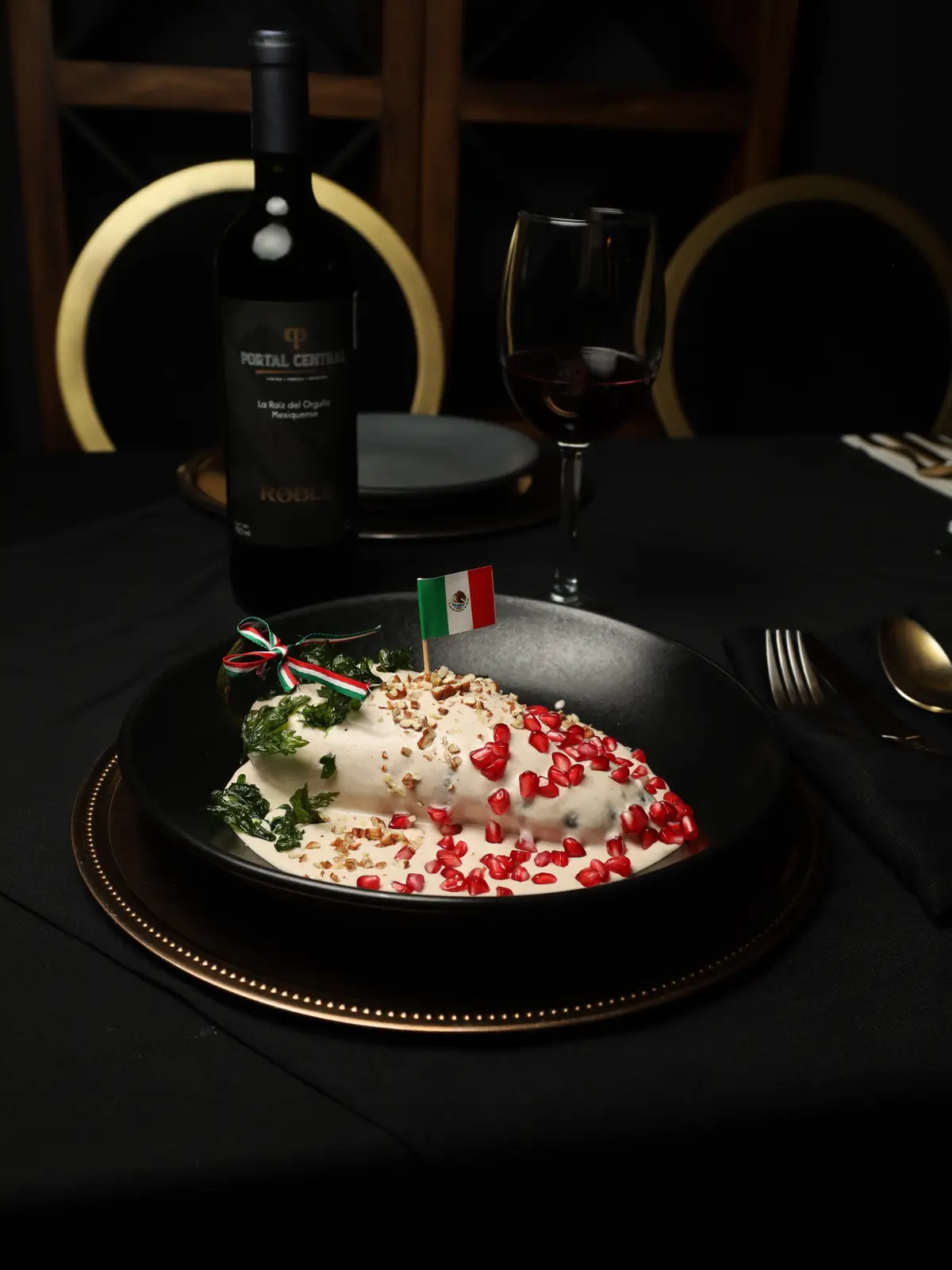 Chile en nogada junto a una botella de vino de la casa